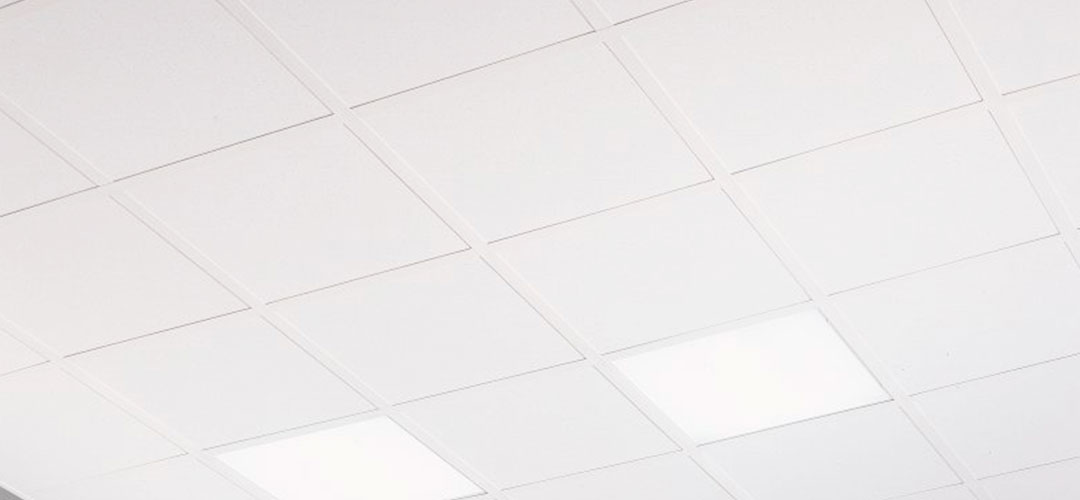 Techo de cielo raso en oficina con acabados en yeso y paneles falsos para interiores modernos.