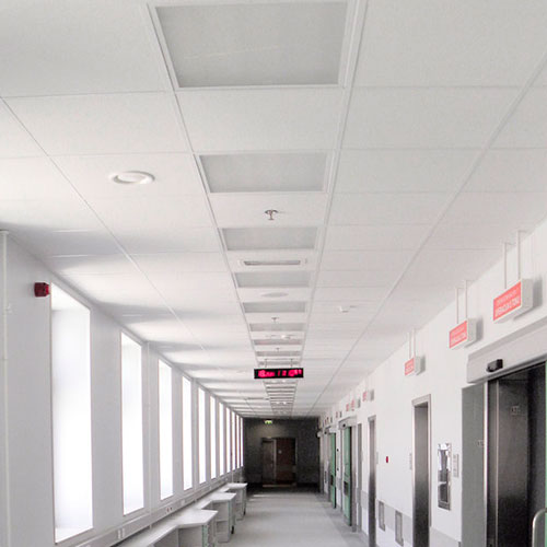 Piso de cielo raso en oficina moderna con iluminación LED y acabados en blanco, ideal para espacios corporativos y comerciales que buscan un diseño minimalista y funcional.